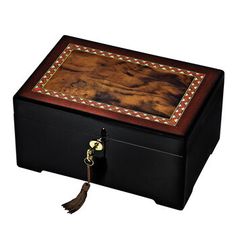 a large wooden box with a tassel on the lid and handles, decorated with leather trimmings