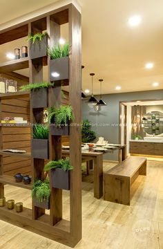 a wooden shelf filled with potted plants on top of a hard wood floor next to a dining room table