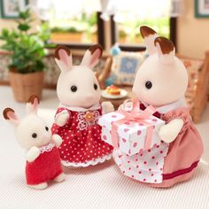 two stuffed animals are standing next to each other with gifts in front of them on the table