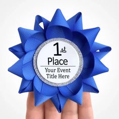 a hand holding a blue award ribbon with the number one place on it's center