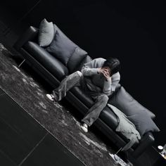 a man sitting on top of a black couch