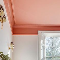 a bedroom with pink walls and white furniture