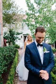 a man in a suit and tie standing next to a woman in a wedding dress