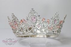 "FAST SHIPPING!! Beautiful silver tiara with pearls and pink crystals. Perfect for your Quinceañera, Wedding, First Communion or Confirmation. It has a loop at the end of each side to attach it in your hair with bobby pins for added security. Approx. 3.25\" tall at its tallest point Approx. 18\" Around Diameter: 6\" DA RNP-150 S-PINK We usually ship within 1-2 business days." Light Pink Quinceanera Crown, Silver Princess Crown With Pinched Shape, Princess Style Wedding Crown, Silver Wedding Crown With Pinched Shape, Silver Rhinestone Wedding Crown, Silver Wedding Crown With Rhinestones, White Wedding Crown With Pinched Shape, White Pinched Crown For Wedding, Wedding Crown With Rhinestones And Pinched Shape