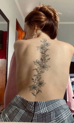 a woman with a flower tattoo on her back