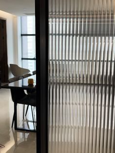 an open door leading to a dining room with a table and chairs in front of it