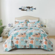 a bed in a room with a blue and orange quilt on top of the bed