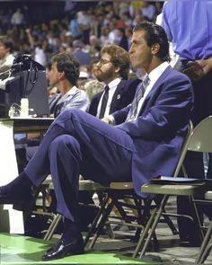 a man in a suit and tie sitting at a podium