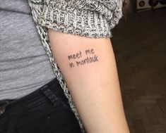 a woman with a tattoo on her arm that says meet me in montauk