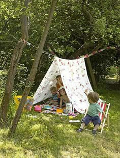 two children are sitting in front of a tent