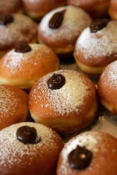 many donuts are covered with powdered sugar and chocolate