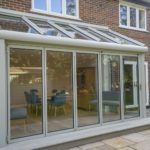 an image of a house that is being built with glass walls and doors on the outside