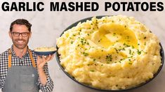 a man holding a bowl of mashed potatoes next to the words garlic mashed potatoes