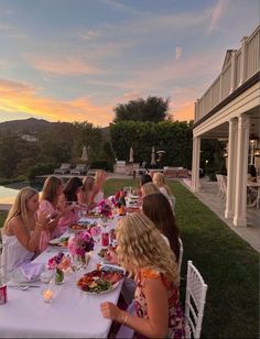 a group of women sitting around a table eating food