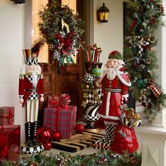 christmas decorations on the front porch of a house with santa clause and other holiday items