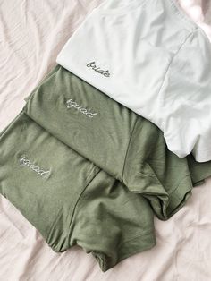 three green and white shirts laying on top of a bed