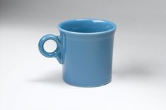 a blue coffee cup sitting on top of a white table