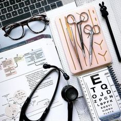 an assortment of eyeglasses on top of a desk next to a laptop computer