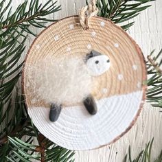 a sheep ornament hanging from a pine tree