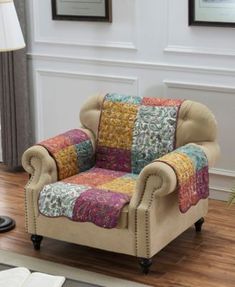 a living room with a couch and chair covered in patchwork fabric on the floor