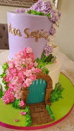 there is a cake that has flowers on the front and side of it, with a door in the middle