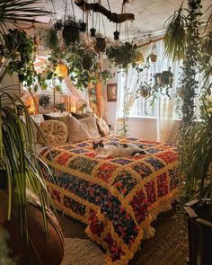 a bed covered in lots of plants next to a window