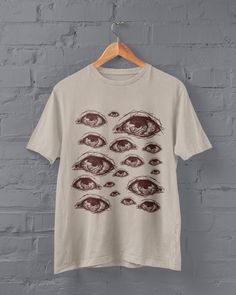 Thanks for stopping by! Grunge Eyes T-shirt Printed on a super soft, cotton tee Dispatched in 5 working days or sooner Unisex Free UK delivery Material: 100% ringspun cotton. Chest (to fit): S  34/36   M  38   L  40/42   XL  44/46   XXL  48/50 ECO-FRIENDLY Each garment is made to order, reducing extra material and energy that would be otherwise wasted We use DTG printing process which is easier on the environment than screen-printing Our ink is bright and also eco-friendly. Do not tumble dry. Wa Creepy Tshirt Design, Halloween Anime Print Grunge T-shirt, Horror Graphic Print Top For Alternative Fashion, Halloween Grunge T-shirt With Anime Print, Grunge Style Fan Merchandise Shirt With Screen Print, Horror Graphic Print Short Sleeve Shirt, Grunge Fan Merchandise Shirt With Screen Print, Horror Graphic Print Tops For Fan Merchandise, Halloween Anime Print Cotton T-shirt