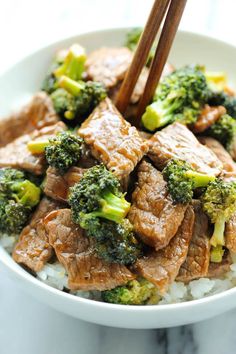 beef and broccoli stir fry in a bowl with chopsticks over rice