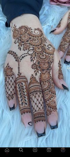 the hands and feet of a woman with henna tattoos