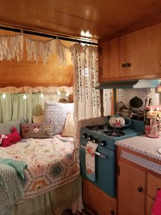 an old fashioned stove and oven in a small room with curtains hanging from the ceiling