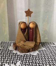 two wooden dolls sitting on top of a piece of wood with a star in the background