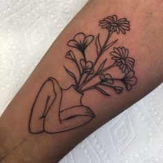 a black and white photo of a woman's leg with flowers on it