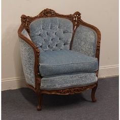 a blue chair sitting on top of a carpeted floor next to a white wall