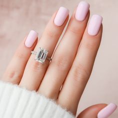 a woman's hand with pink manicured nails and an engagement ring