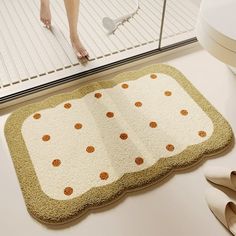 a bathroom rug with orange polka dots on it