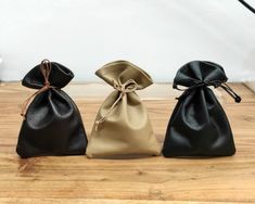 three black and gold bags sitting on top of a wooden table