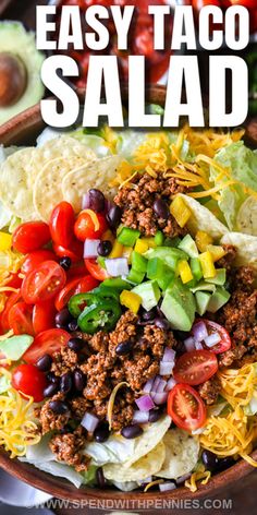 taco salad with lettuce, tomatoes, black beans and cheese in a bowl