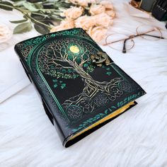 a book with a tree on it sitting on top of a white fur covered bed