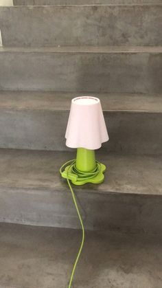 a green lamp sitting on top of a set of stairs next to a stair case