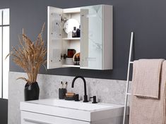 a white sink sitting under a bathroom mirror