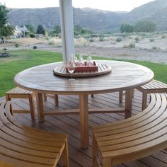 a table and chairs on a deck with mountains in the background