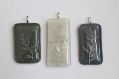 three rectangular pendants with flowers on them