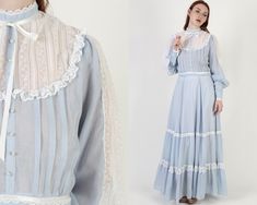 "This is a vintage 1970s Gunne Sax Victorian western prairie dress. It has a tailored bodice with sheer lace chest with long balloon puff sleeves. There is an attached waist sash and the gathered skirt is sweeping and tiered. It is made of powder blue cotton voile material. The dress zips up the back and the skirt is lined. Sold in great, pre-owned vintage condition. Please review detailed measurements below for an accurate fit. tag size: 11 shoulders: 14\" bust: 38\" waist: 27\" hips: 40\" tota Saloon Dress, Lace Balloons, Gunne Sax Dress, Pink And White Dress, Balloon Sleeve Dress, Royal Dresses, Century Clothing, Floral Robes, Europe Fashion