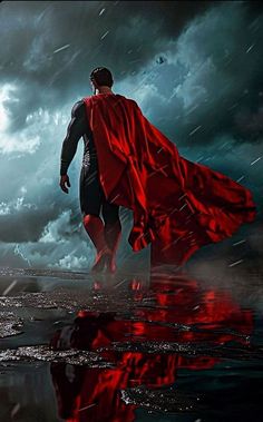 a man dressed as superman standing in the rain with his cape over his head and hands on his hips