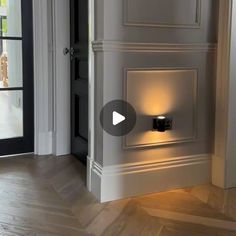 an open door with a light on it in a room that has wood floors and white walls