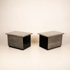 two black and grey boxes sitting on top of each other in front of a white wall