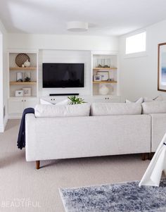 a living room filled with furniture and a flat screen tv on top of a wall