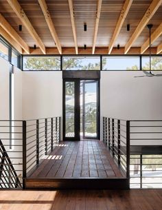 an empty room with wooden floors and railings