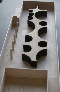 a wooden structure with black and white designs on it's sides, sitting on top of a table