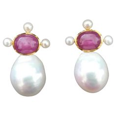 These elegant and handmade earrings have 2 Oval Natural Ruby cabs measuring 8 x 10 mm set in a 14 Kt yellow gold bezel with 3 small round pearls of 3 mm on 3 sides at the top to which are suspended 2 very good luster White Pear Shape Baroque Pearls measuring 14x16 mm and weighing 45 carats. In 1978 our workshop started in Italy to make simple-chic Art Deco style jewellery, completely handmade and using the typical gemstones of that period (1920-1930 circa) : genuine Jades, Turquoise , Lapis Lazuli and other color gemstones set in white Gold, Diamonds and Enamels. We always put particular attention on the details of the antique jewels,like "Milgrain" setting and light use of gold, so our pieces are affordable, easy and comfortable to wear. Today we also offer our experience to realize your Ruby Earrings Studs, Emerald Earrings Studs, White Gold Jewelry, Pear Shaped Diamond, Modern Earrings, Pearl Stud Earrings, Natural Ruby, Pearl Studs, Baroque Pearls